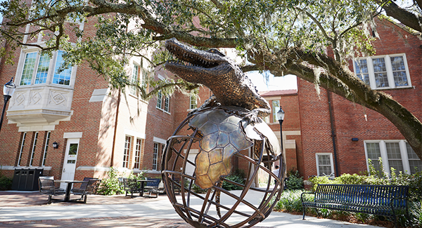 Photo of bronze sculpture of gator on a globe